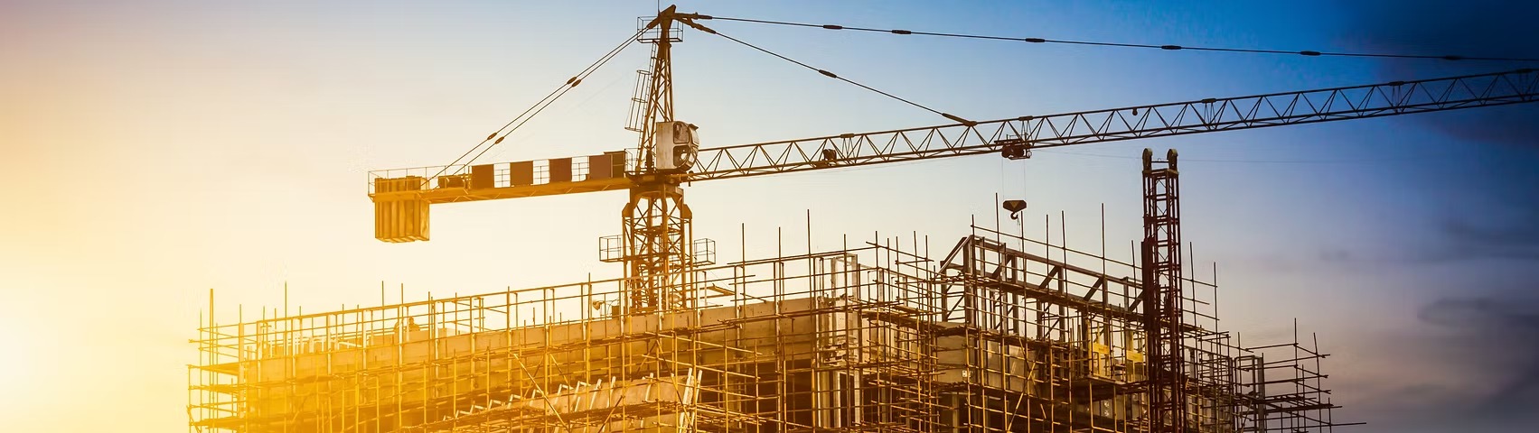 Estrutura de obra com guindaste e andaimes representando gestão digital da construção